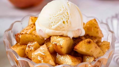 Microwave Baked Apples in a Glass Dish with a Scoop of Vanilla Ice Cream