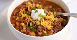 Homemade Crockpot Taco Soup with Shredded Cheese, Corn, Sour Cream, Onions and Ground Beef