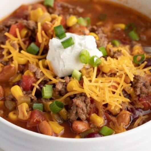 Homemade Crockpot Taco Soup with Shredded Cheese, Corn, Sour Cream, Onions and Ground Beef