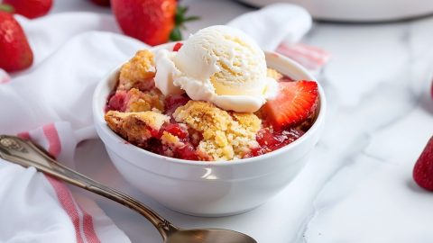 Homemade fluffy and gooey strawberry cobbler in a white bowl