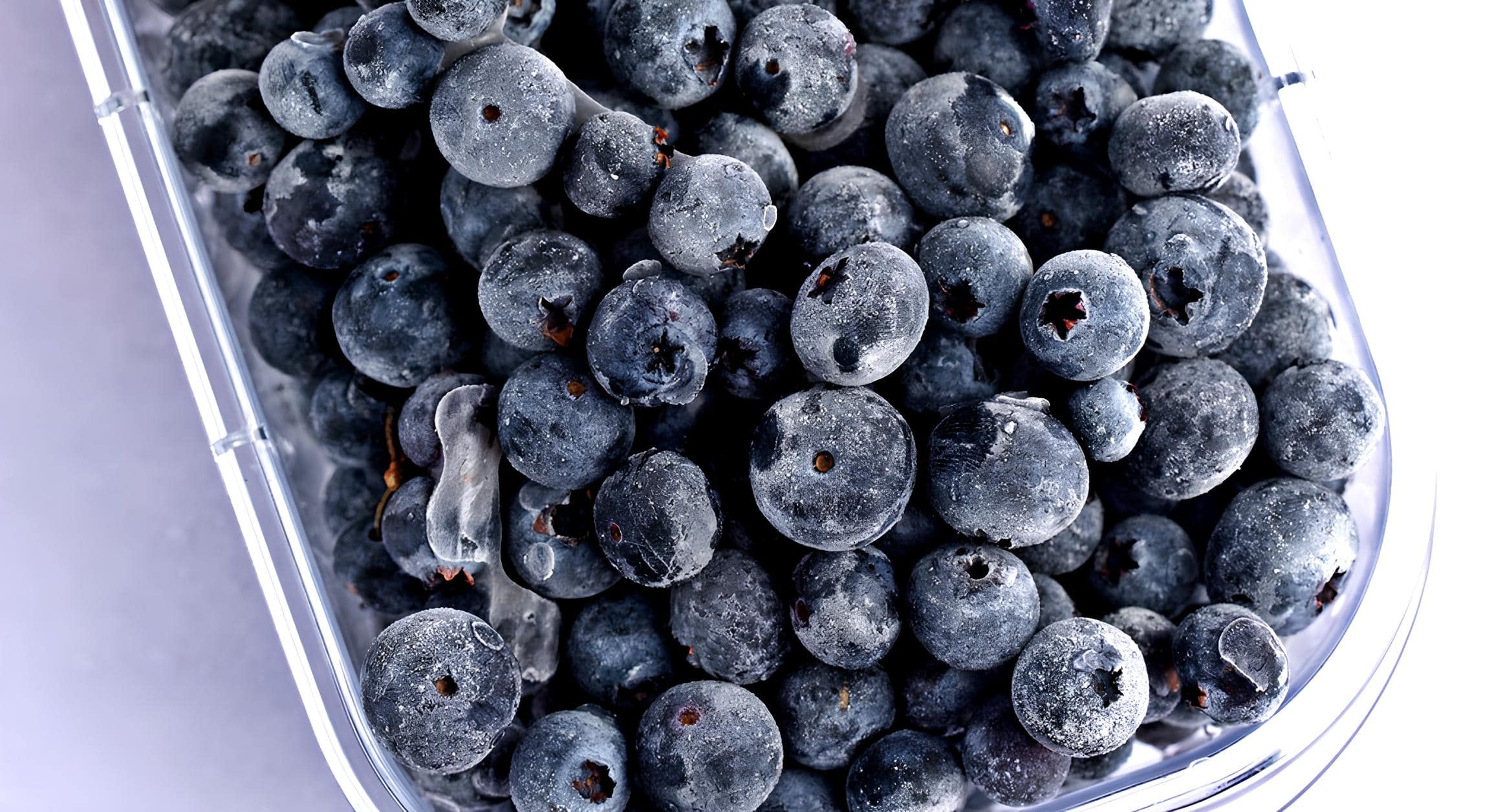 A Plastic Container Filled with Frozen Blueberries