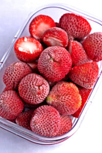 Red Frozen Strawberries in a Plastic Container
