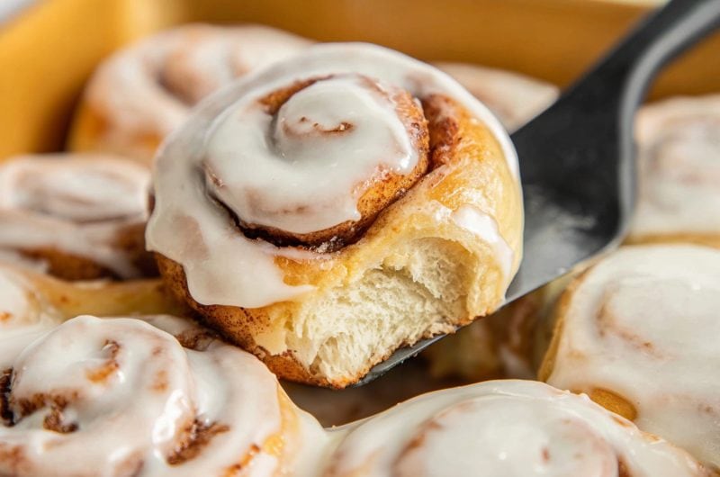 A close-up of Bisquick cinnamon roll lifted by a spatula.
