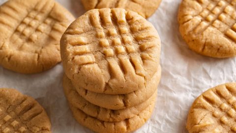 Bisquick peanut butter cookies stacked on a white parchment paper, close-up