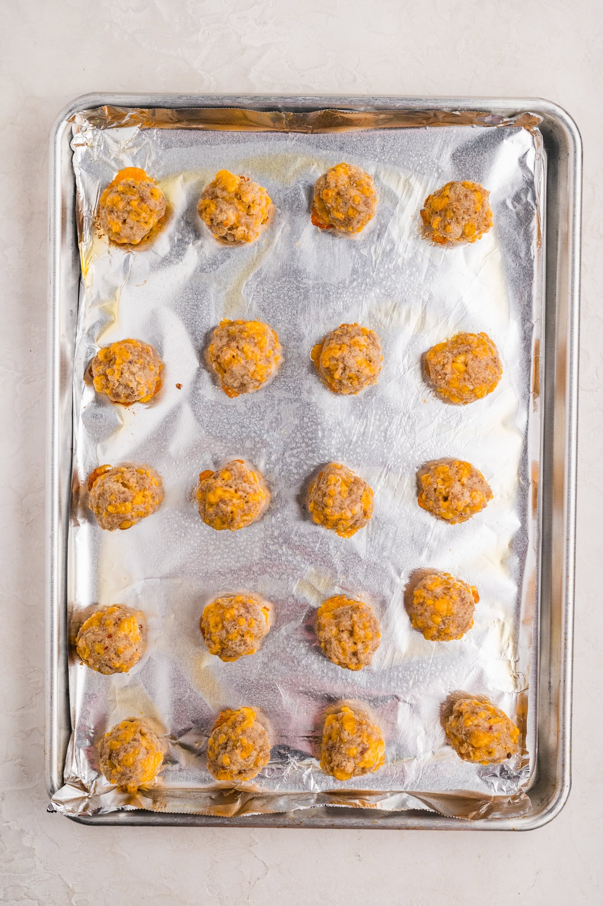 cooked sausage balls on parchment-lined baking sheet