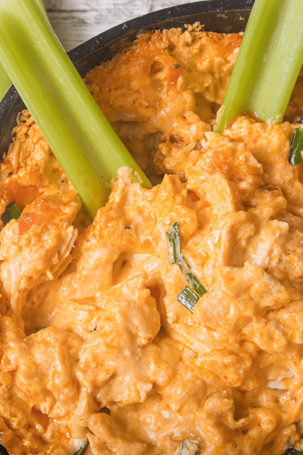 Celery sticks dipped in a bowl of Buffalo Chicken Dip