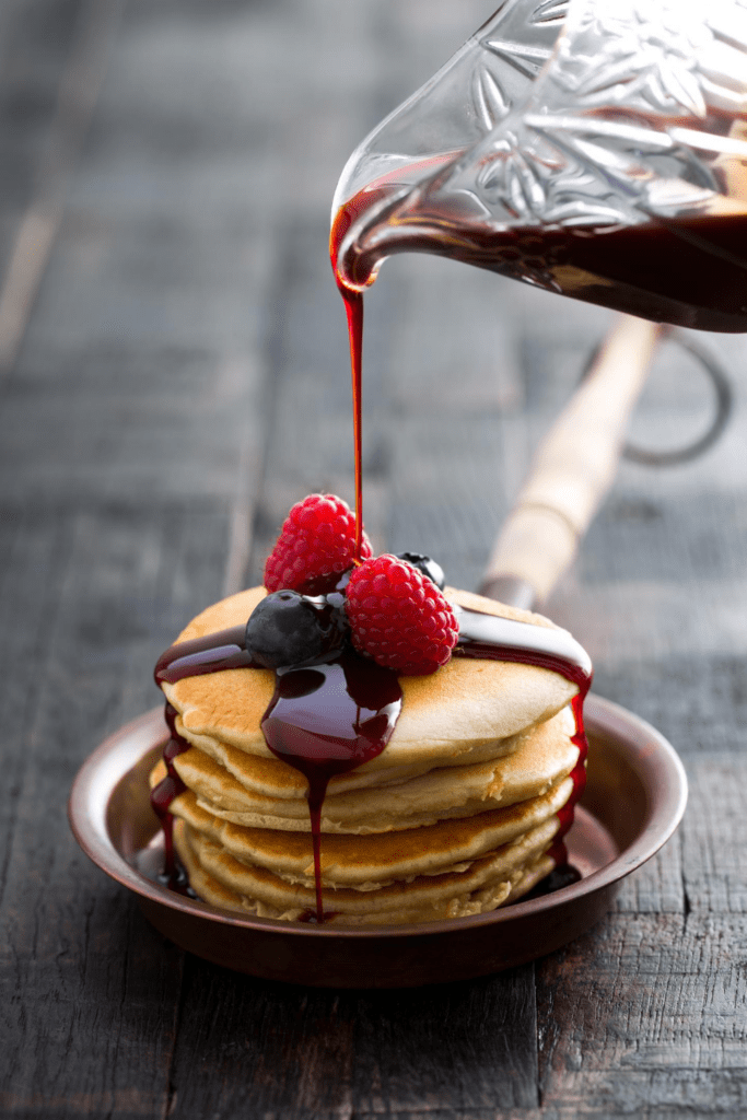 Stacks of Pancakes with Berries and Blueberry Syrup
