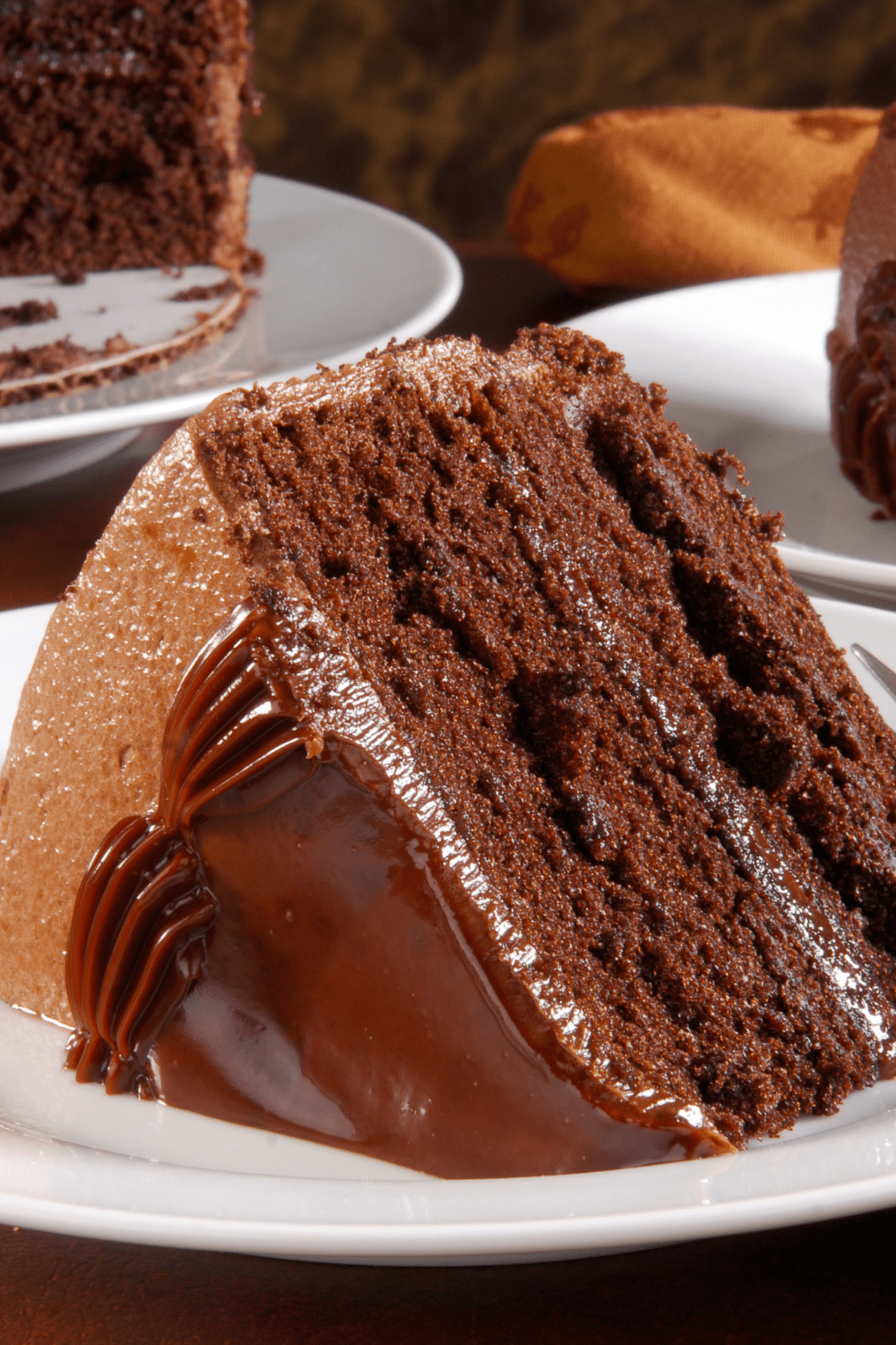 A slice of chocolate cake with chocolate cream on top. 