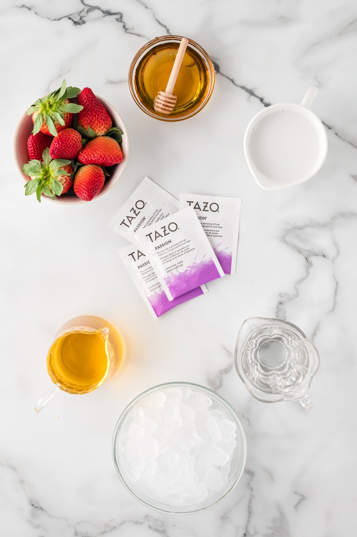 Starbucks Pink Drink ingredients - fresh strawberries, white grape juice, TAZO passion tea bags, coconut milk, ice, and agave syrup, top view