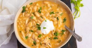 Bowl of Warm Chicken Chili with Sour Cream and Herbs