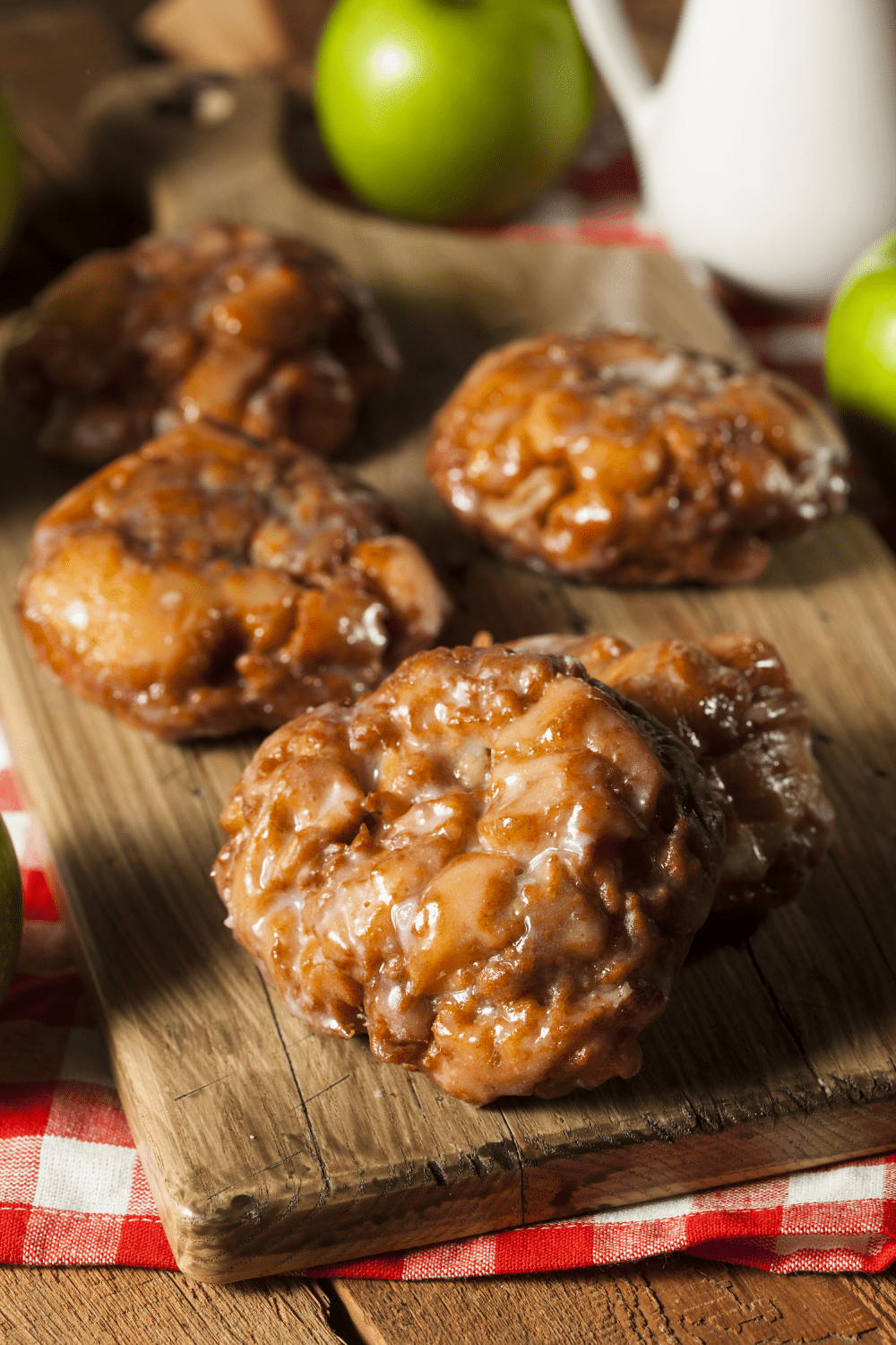 Homemade Glazed Apple Fritters in a wooden board. 