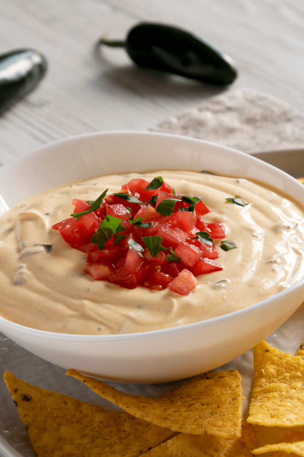 Questo Dip topped with tortilla chips and chopped tomatoes.