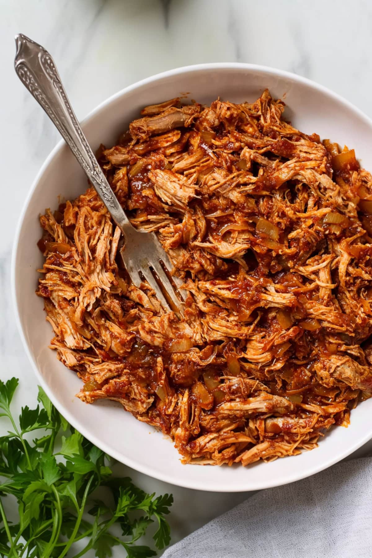 Pulled pork with barbecue sauce in a white plate.