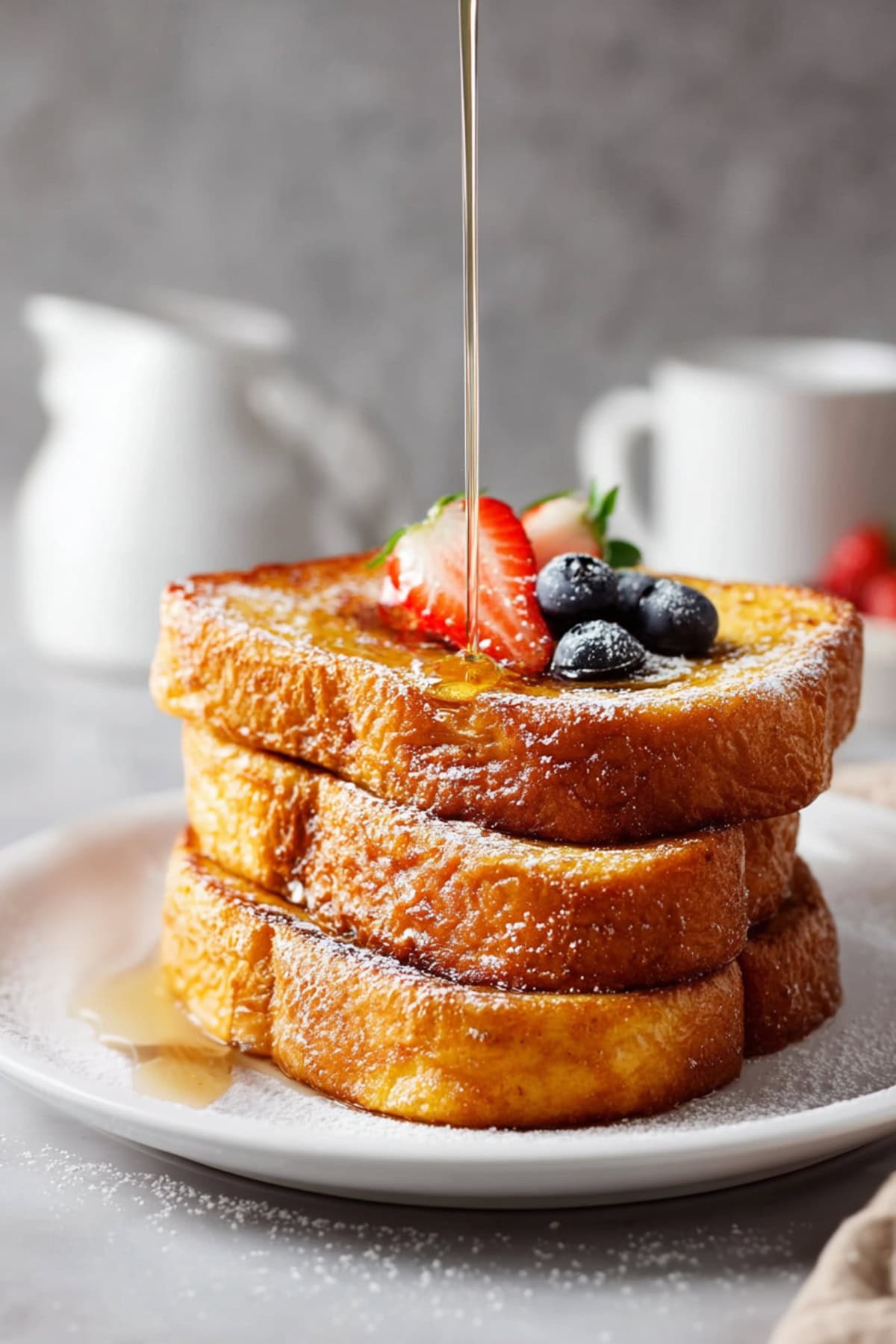 Stacked sliced of Cracker Barrel french toast bread topped with blueberries and strawberries, and drizzle with maple syrup.
