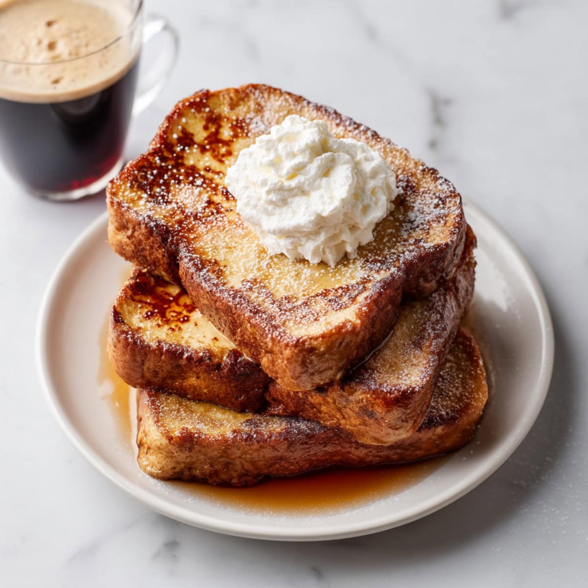 Baileys french toast with a light dusting powdered sugar and topped with whipped cream.