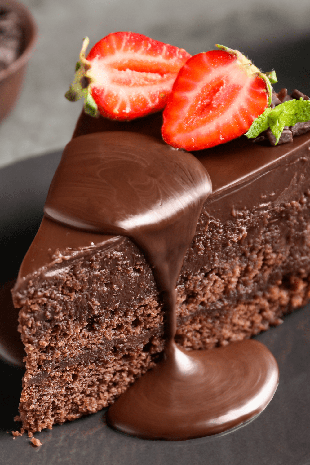 A slice of chocolate cake with strawberry and chocolate syrup