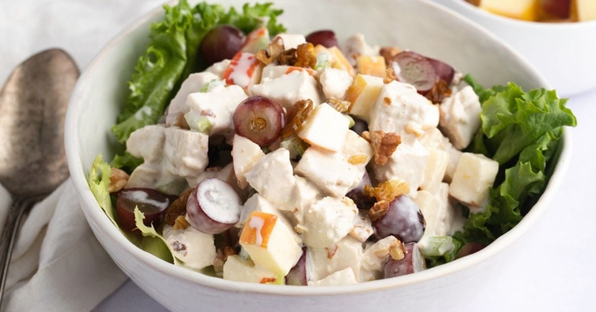 Homemade Chicken Waldorf Salad with Fruits, Walnuts and Lettuce in a Bowl