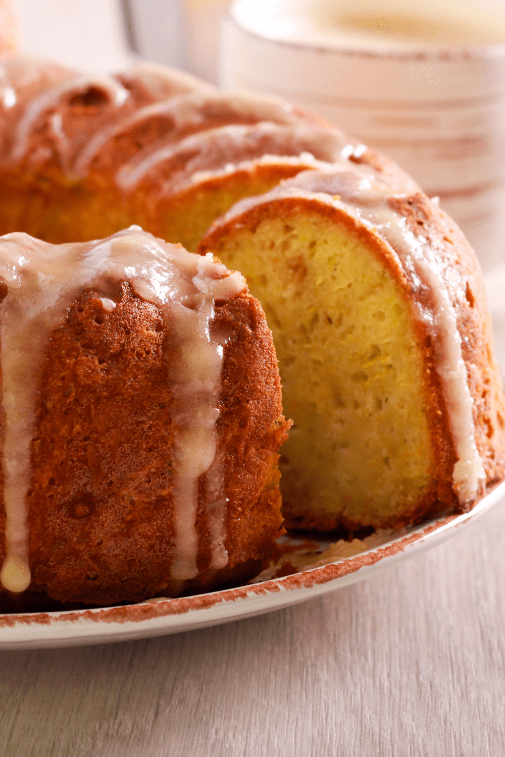 Bundt cake with a slice missing with dripping sugar glaze. 