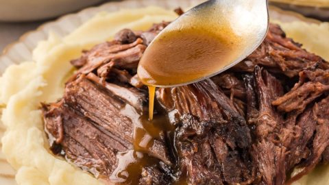 Gravy poured over shredded Mississippi pot roast served on top of mashed potato.