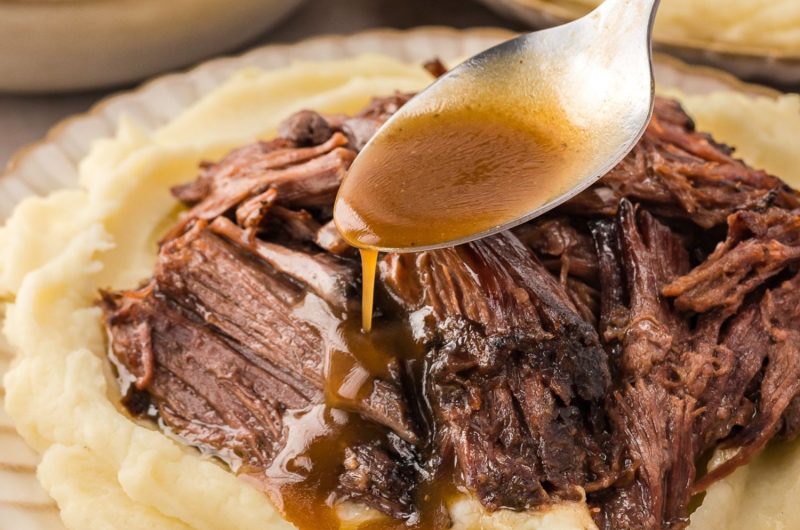 Gravy poured over shredded Mississippi pot roast served on top of mashed potato.