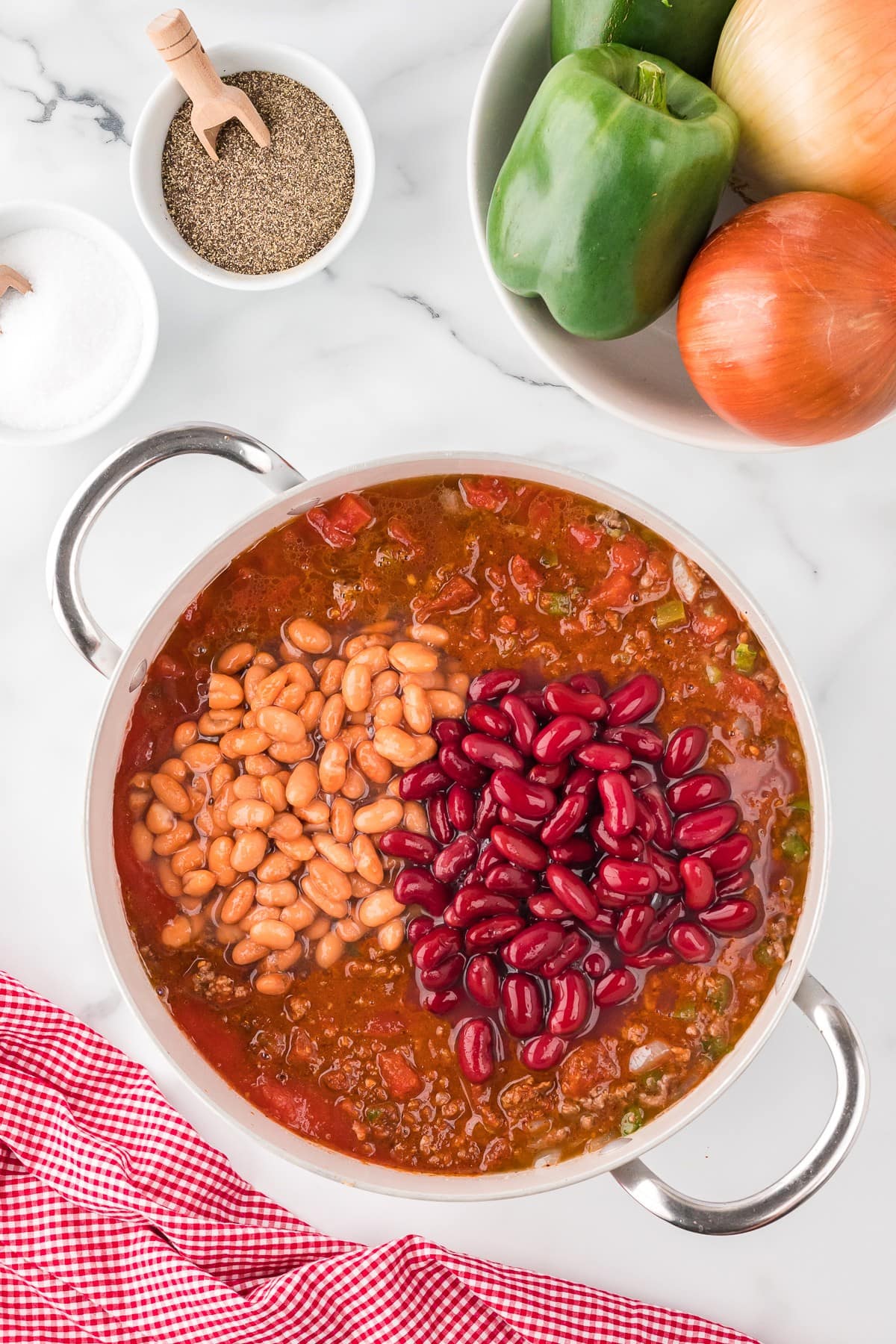 Beans, ground beef, bell peppers and tomato sauce in a large pot, top view