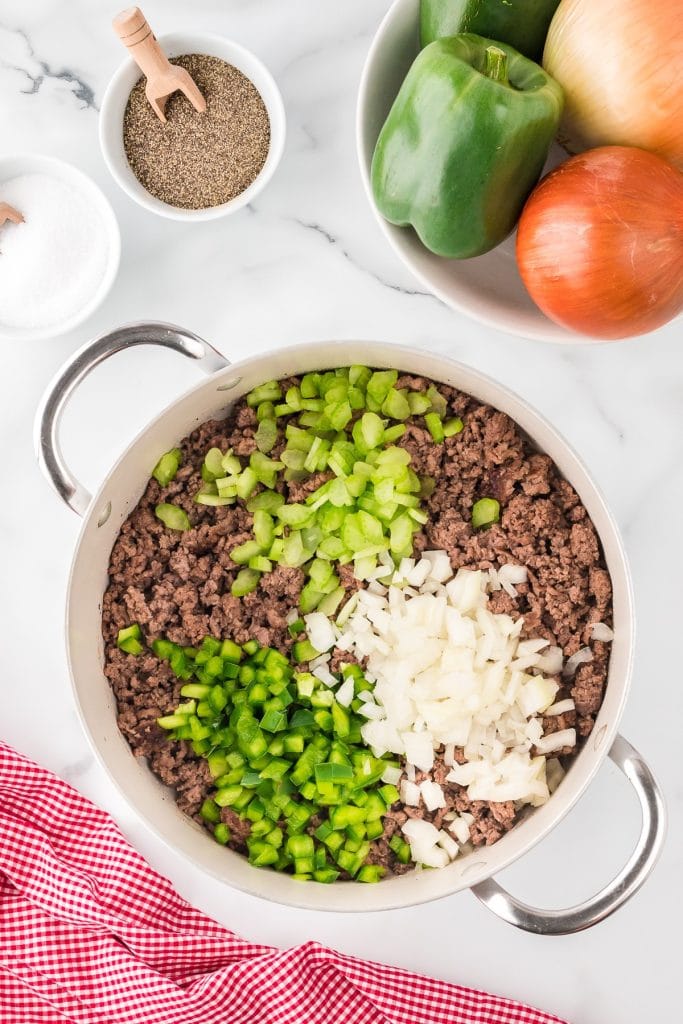 Ground beef, diced celery, onions and bell peppers in a large pot, top view