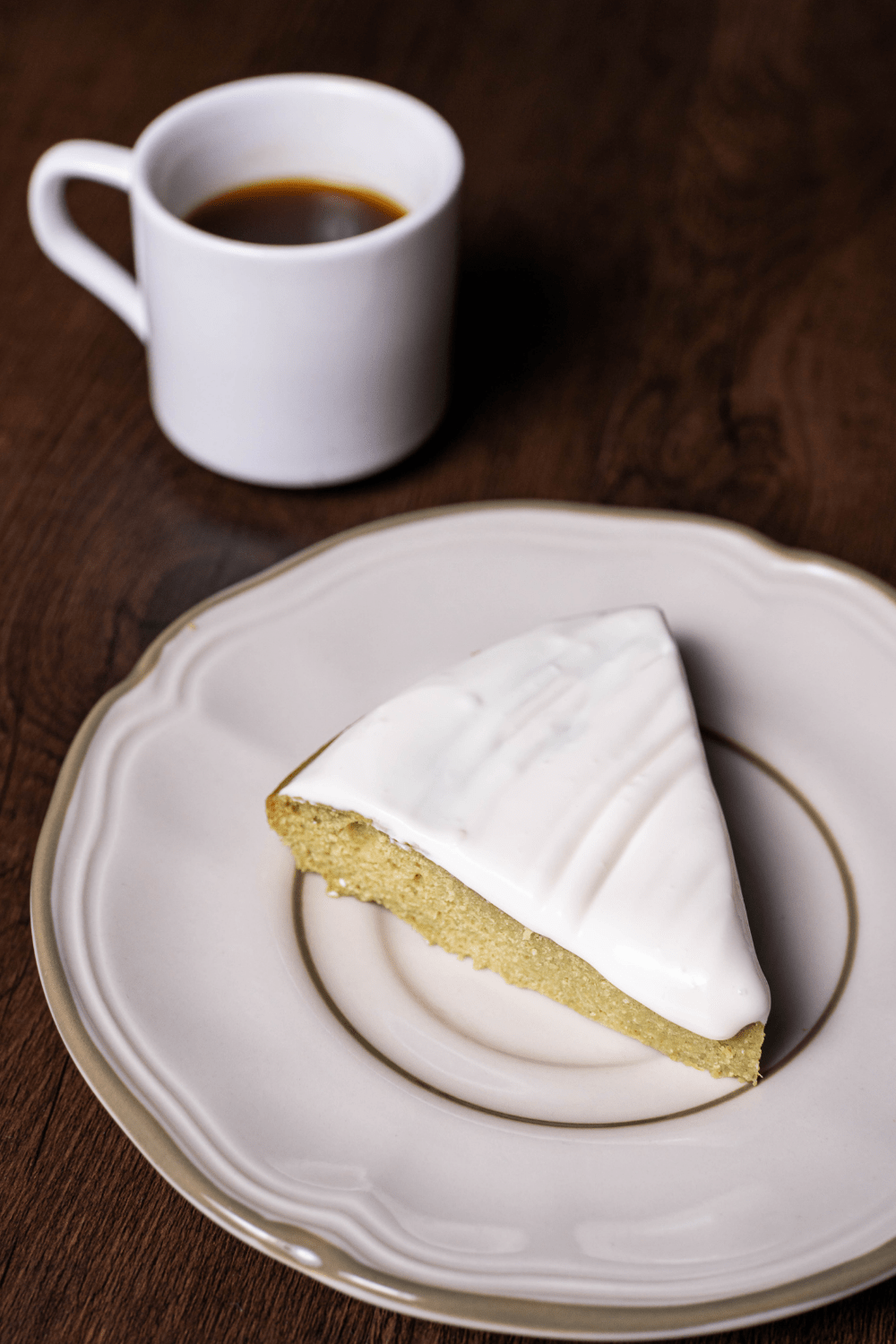 A slice of key lime cake with a cup of coffee