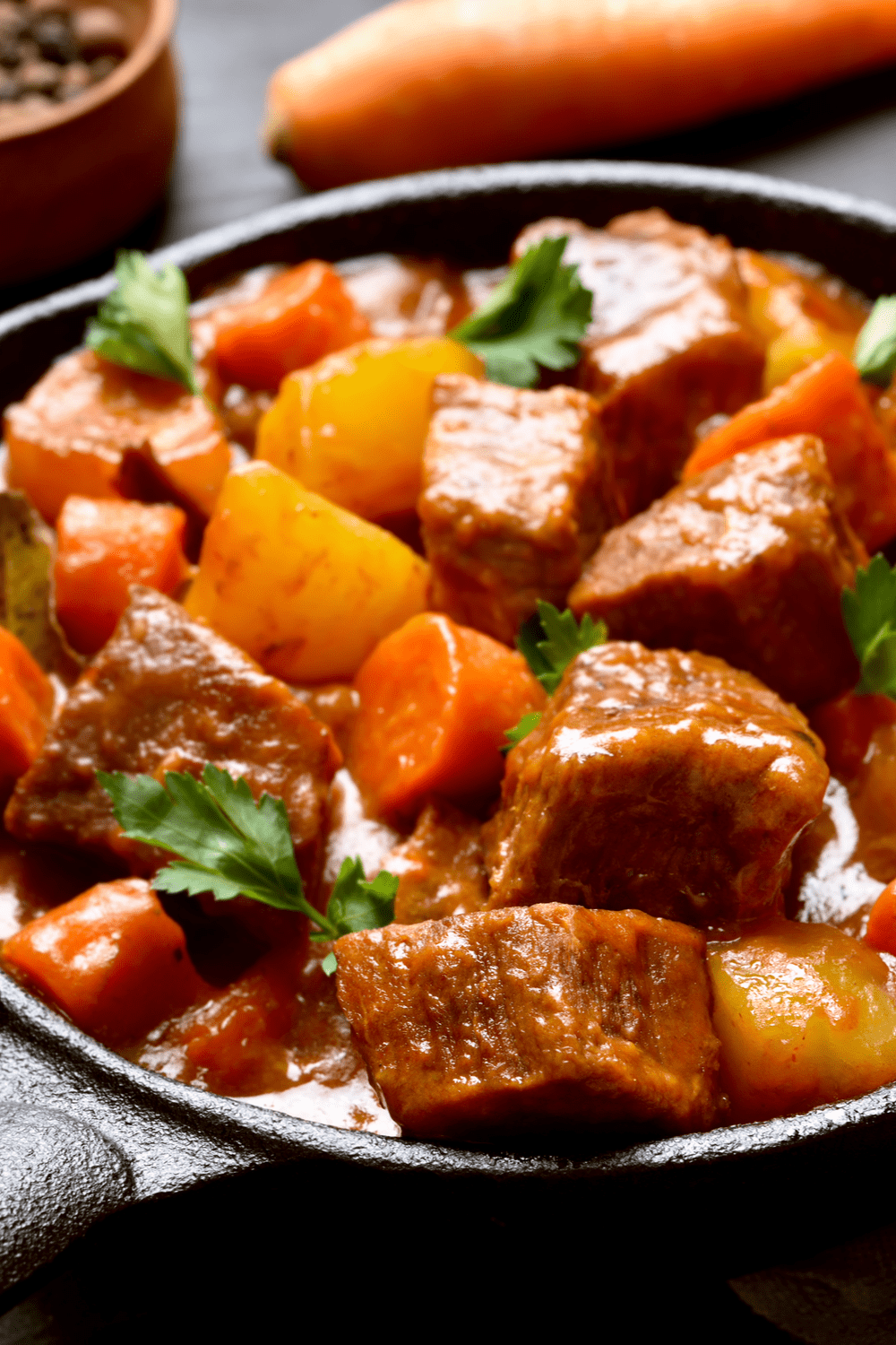 Beef Stew with carrots and potatoes cooked on a cast iron. 