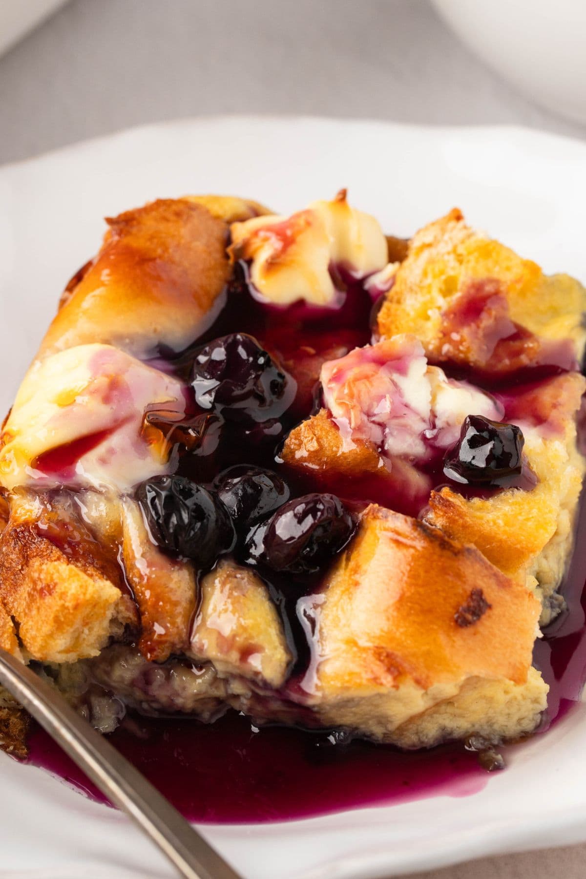 A slice of blueberry French toast served with blueberry jam on top in a white plate. 