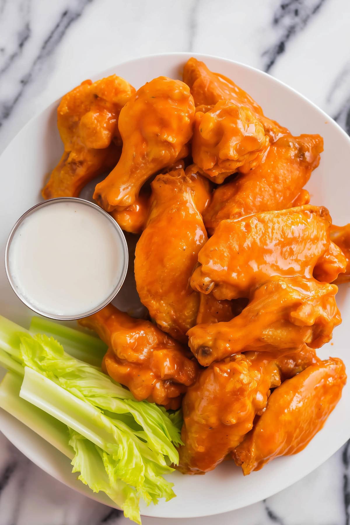 Close-up of buffalo chicken wings with a glossy orange glaze.