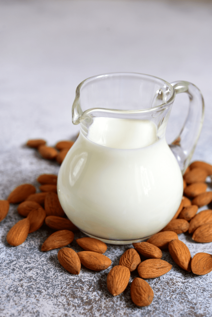  Almond Milk in a Jug with Almonds surrounding it