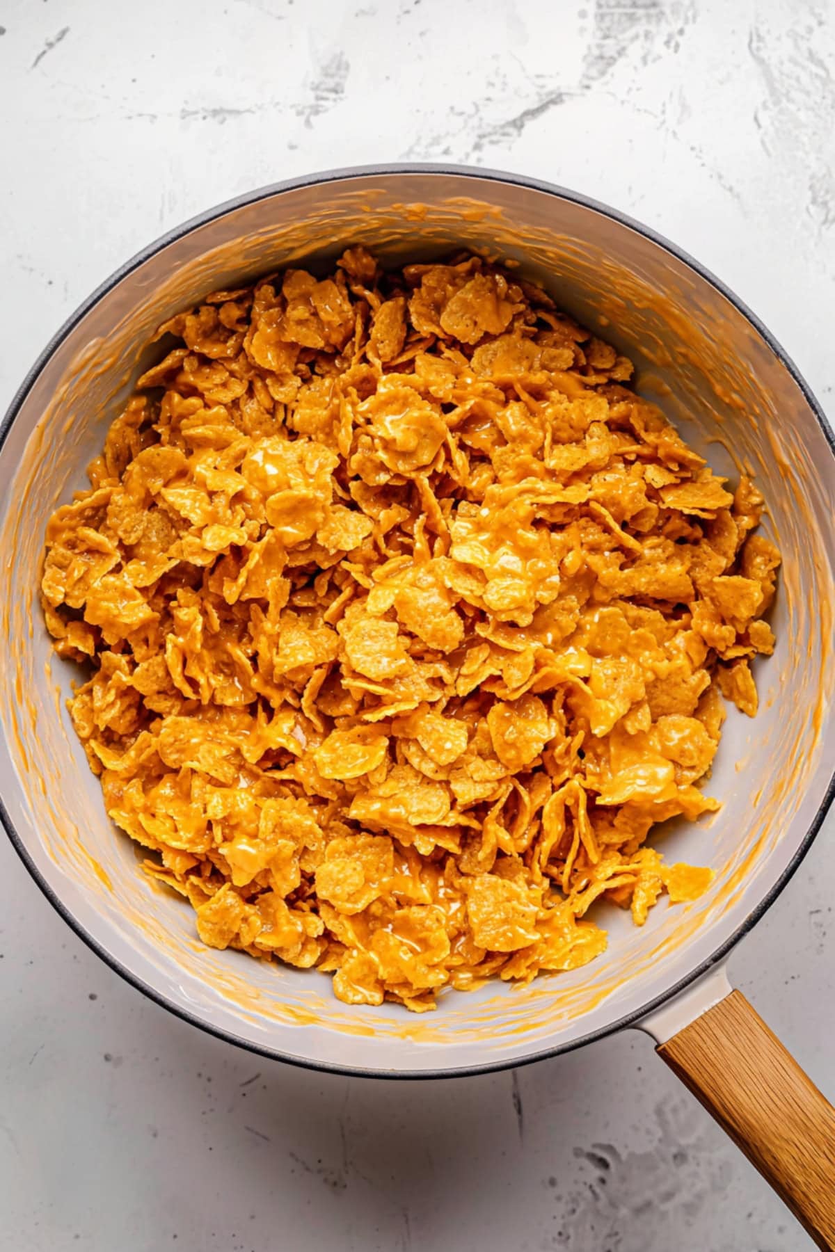 Mixed cornflakes and peanut butter in a large saucepan.