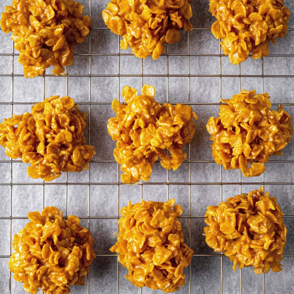 An overhead view of peanut butter cornflake cookies in a cooling rack.