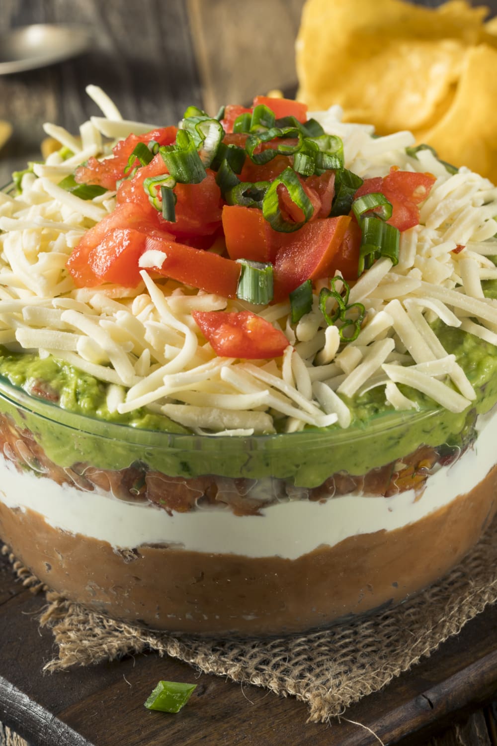 Seven Layer Taco Dip served on a huge glass bowl. 