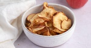 Homemade Sweet and Crispy Apple Chips in a White Bowl