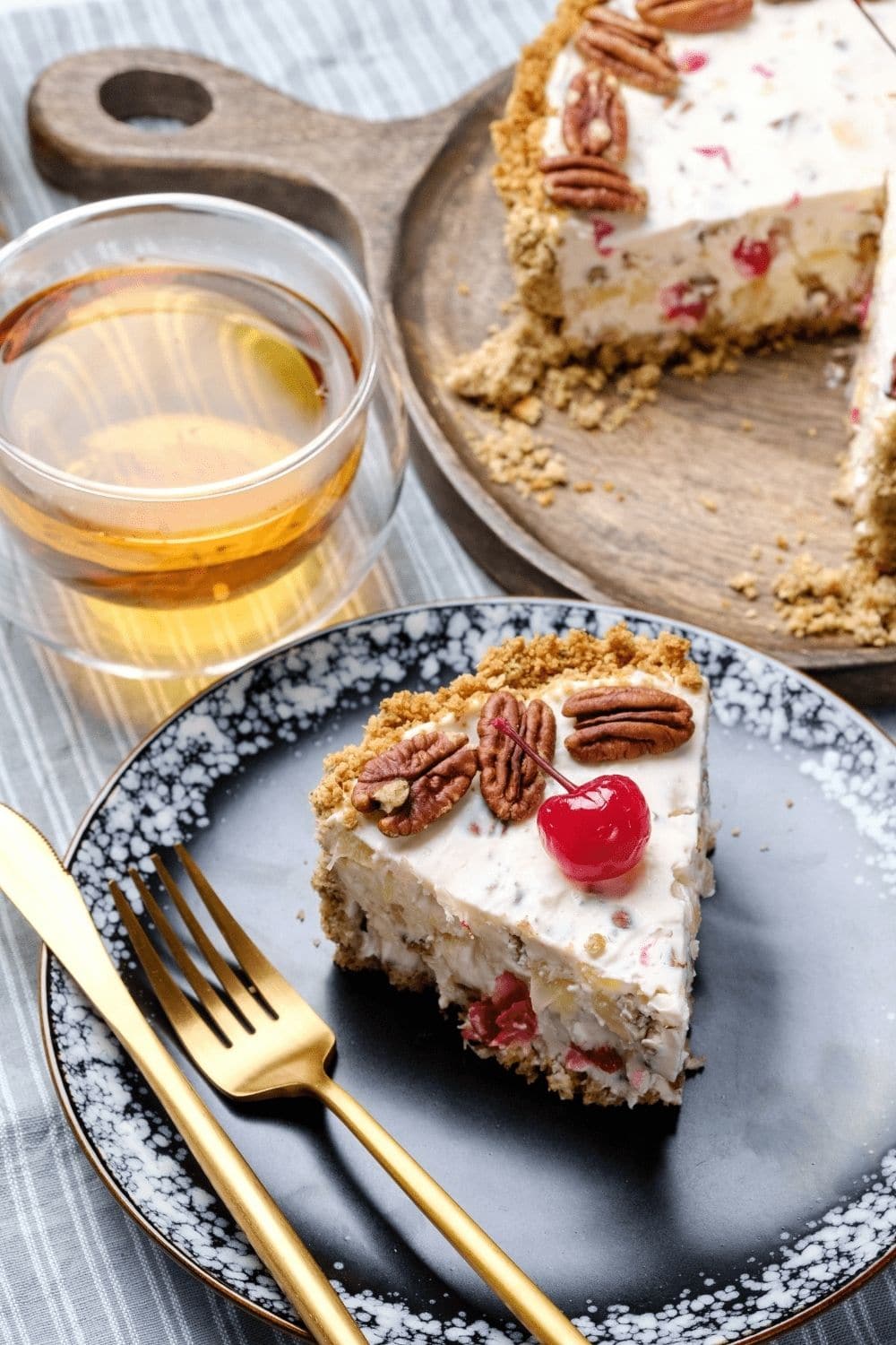 A slice serving of Millionaire's pie topped with pecans and cherry. 