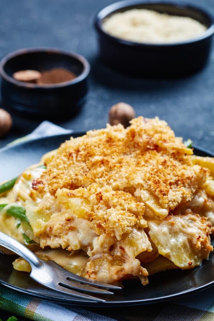 20 Best Potato Casserole Recipes. Photo shows Cheesy Potatoes with Bread Crumbs and green beans