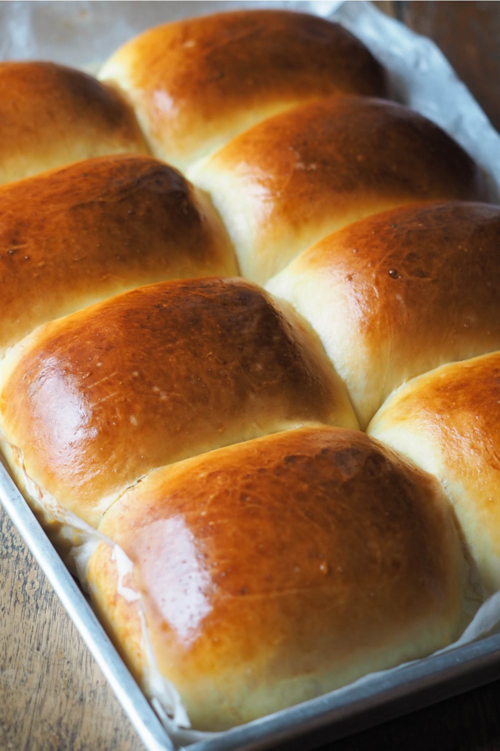 Dinner Rolls on a baking pan with parchment paper liners.