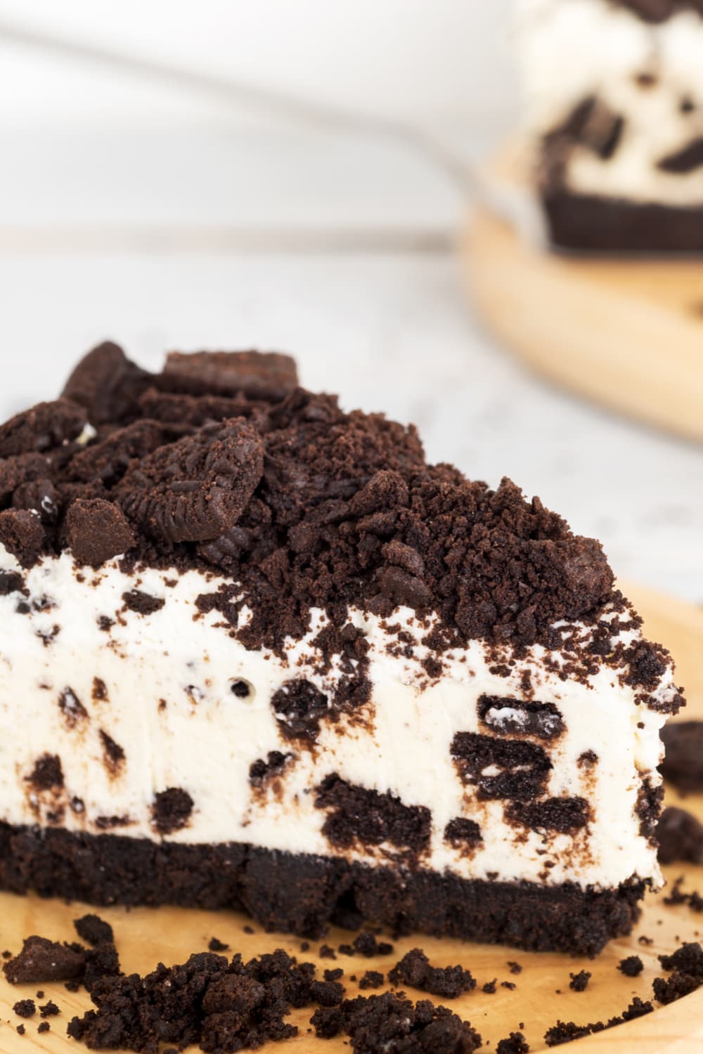 A slice of cheesecake covered with crushed oreo.