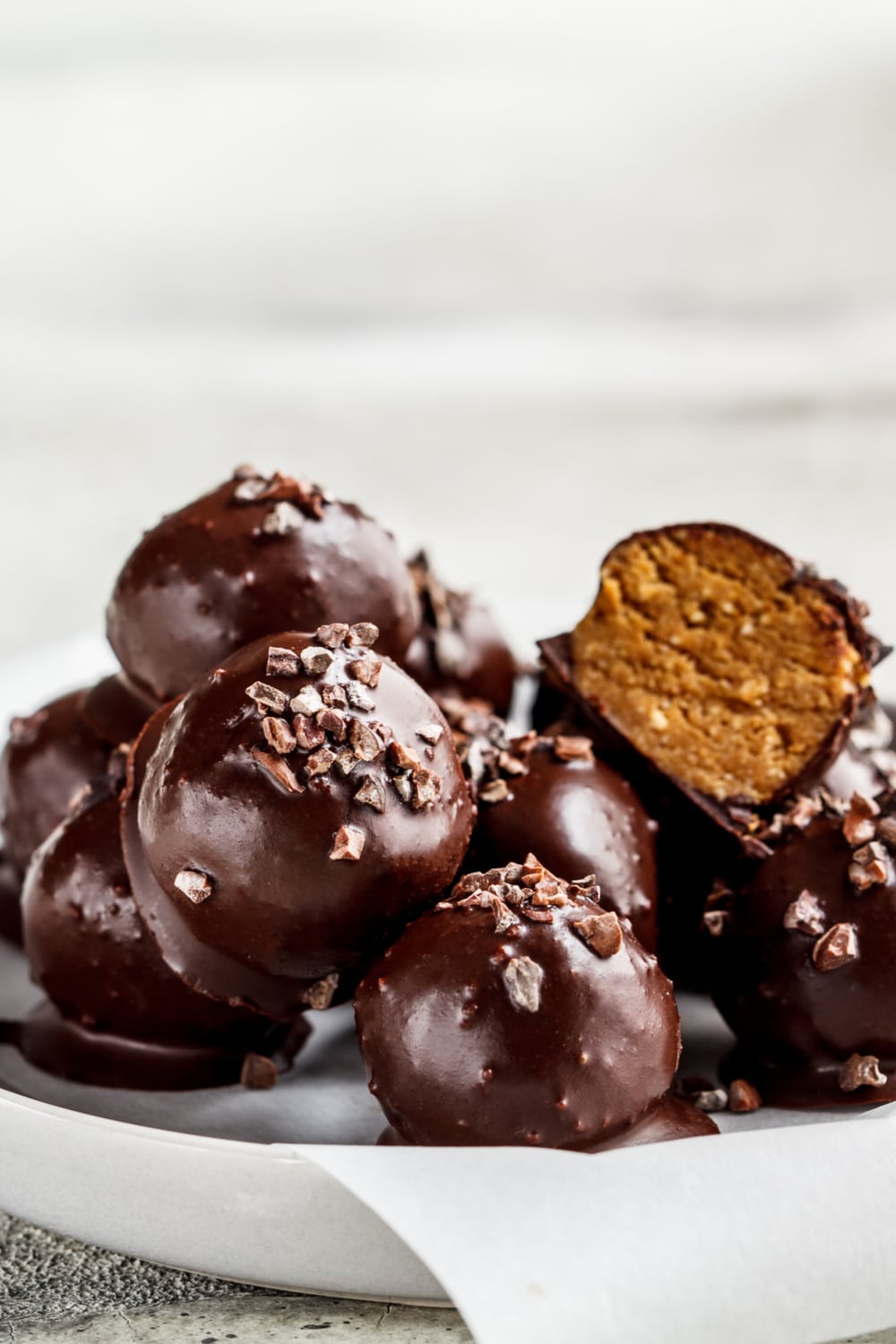 Bunch of chocolate coated peanut butter balls with crushed pretzels.