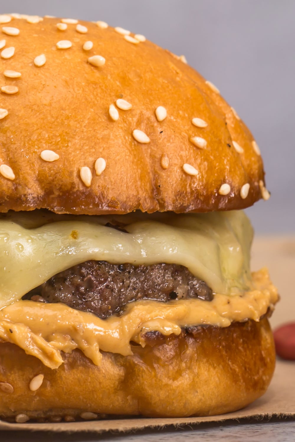 Closeup of peanut butter burger with thick patty and melted cheese filling. 