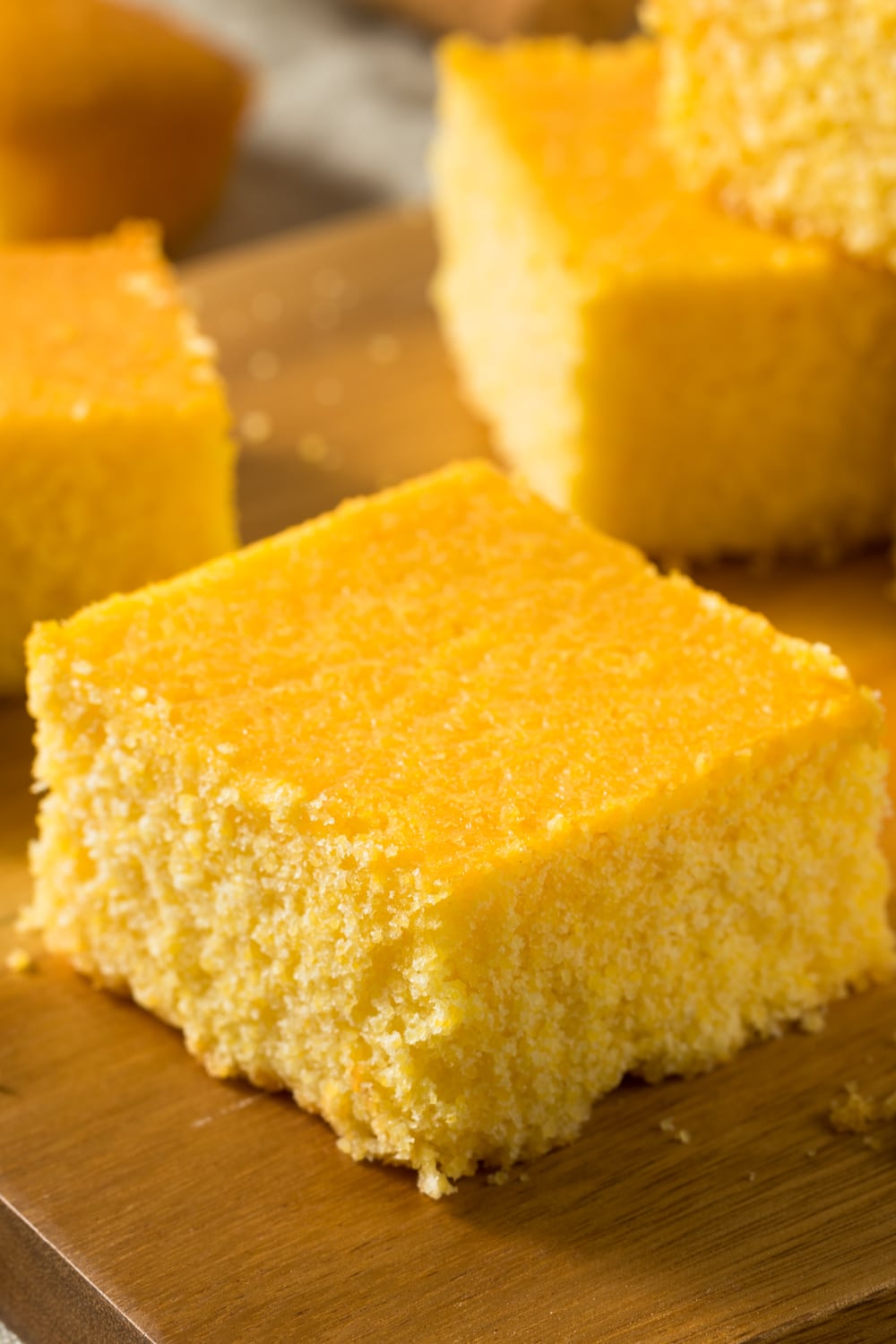 Slices of cornbread on a wooden board. 