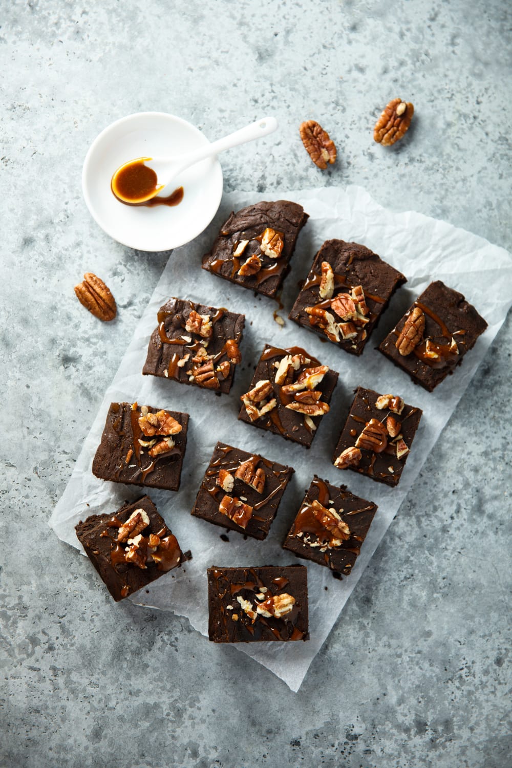 Brownies fudge with chopped pecans and a drizzle of caramel syrup.