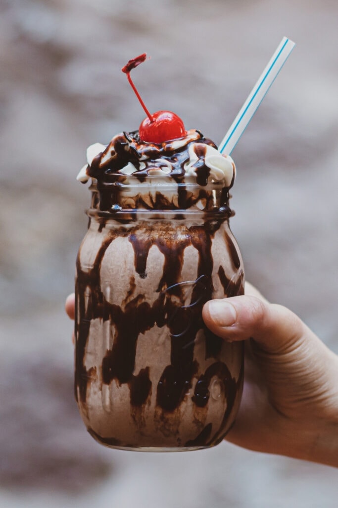 Holding a Chocolate Shake with Cherry Topping