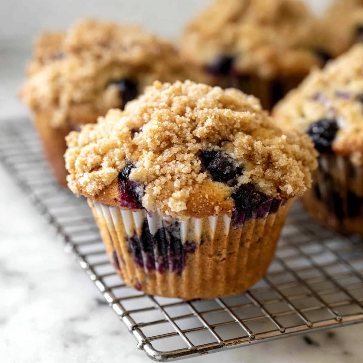 A close-up of blueberry muffins in a cooling rack.