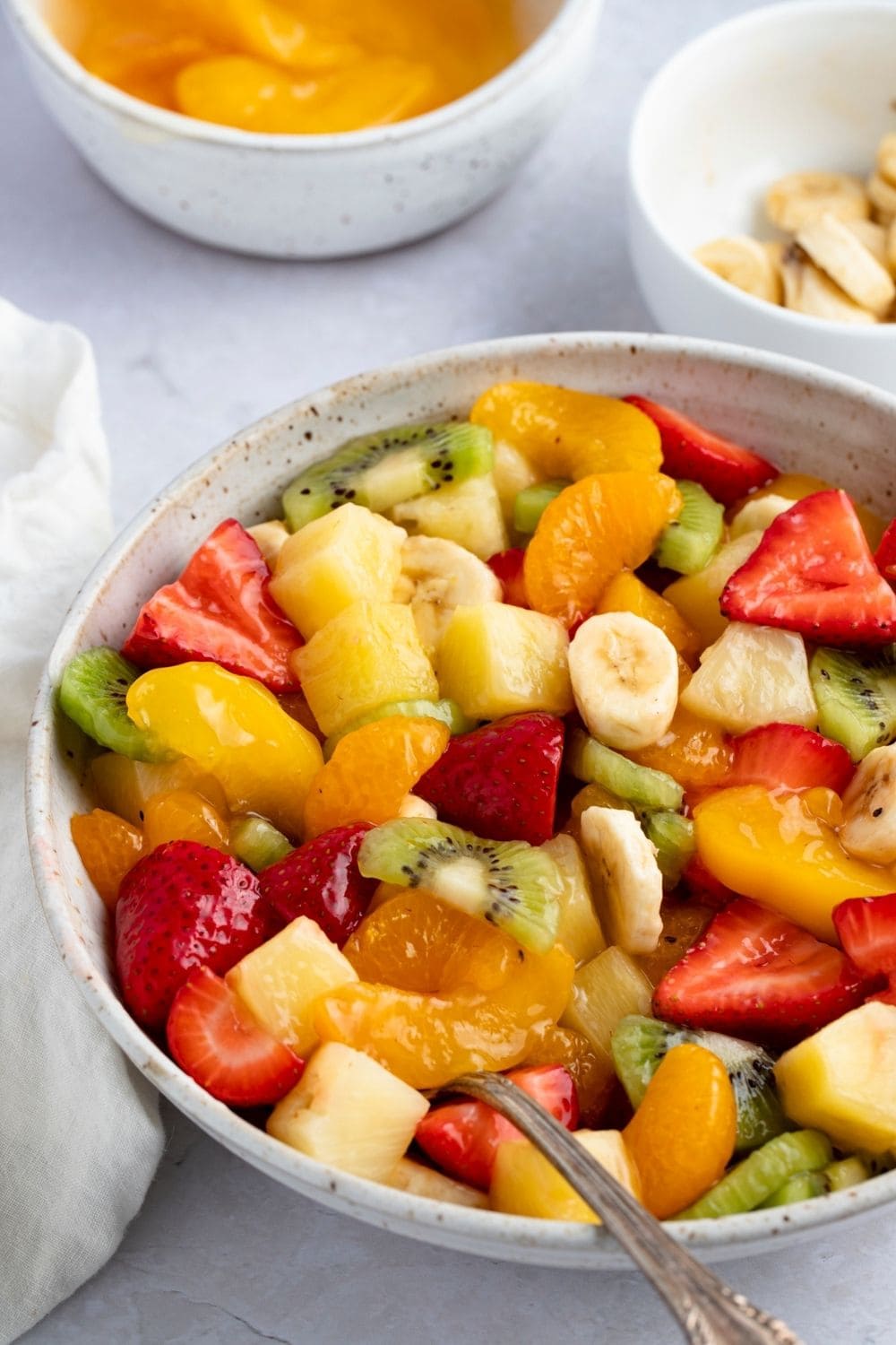 Bowl of Fruit Salad with Bowl of Fruit Salad with mix chopped strawberries, kiwi, peach, pineapple, oranges and bananas