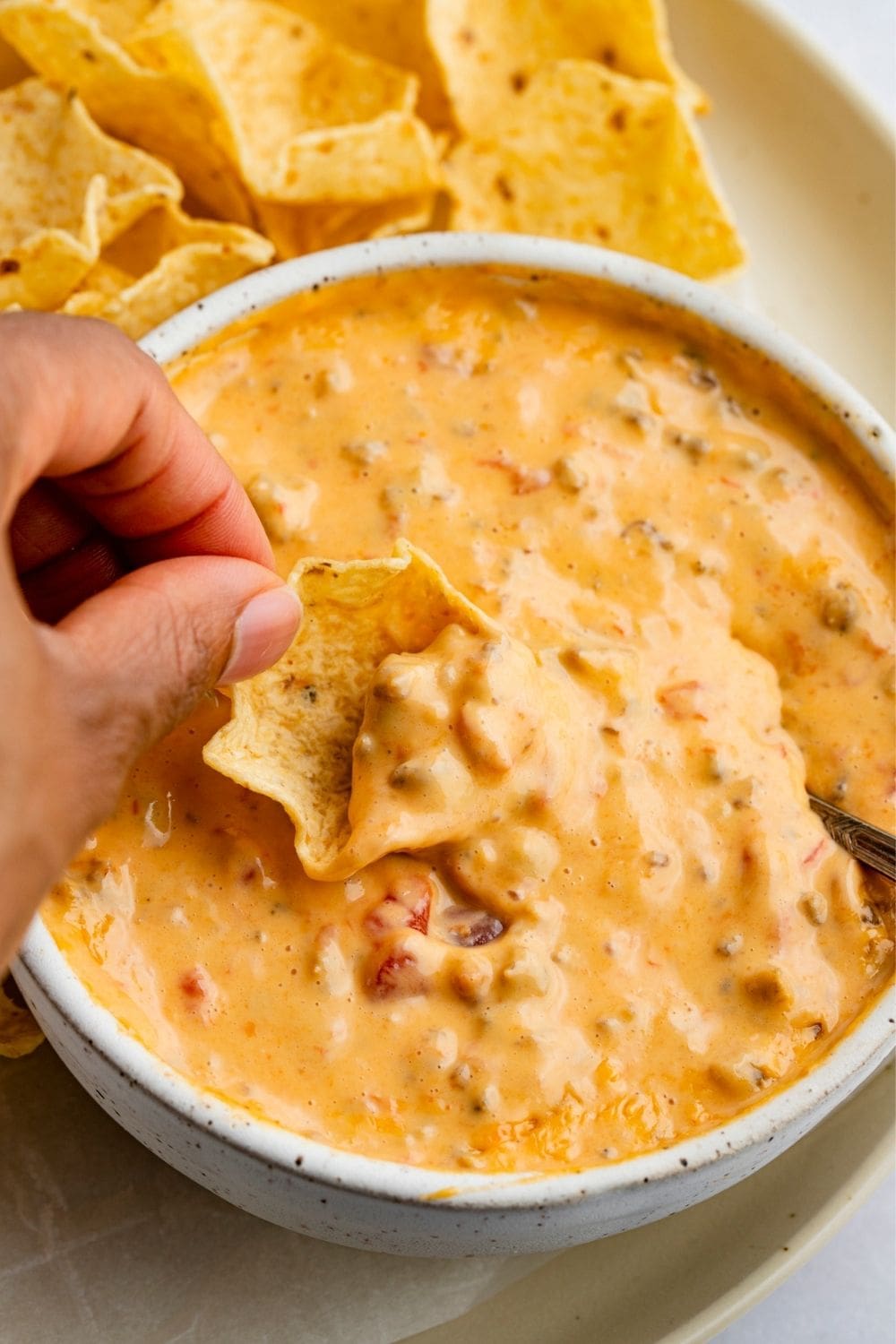 Dipping Tortilla Chips on a Cheesy Sausage Dip