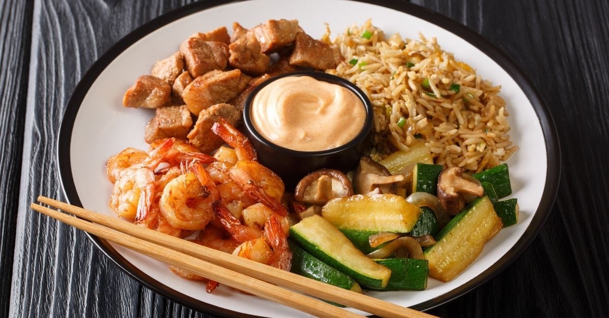 Hibachi Dish: Fried Rice, Zucchini, Shrimp, and Steak Served with Sauce in a Plate