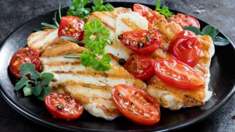 Homemade Grilled Halloumi Cheese with Tomatoes on a Black Plate