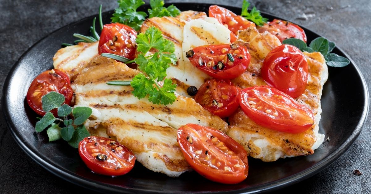 Homemade Grilled Halloumi Cheese with Tomatoes on a Black Plate